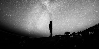 Silhouette of man looking up towards The Milky Way.