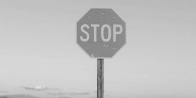 Hexagon stop sign with clouds in background